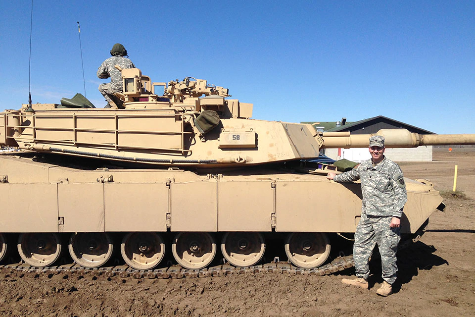 Thielen in uniform in front of tank